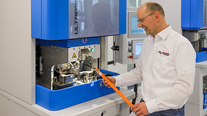 Herrmann employees inspecting an ultrasonic welded busbar connection